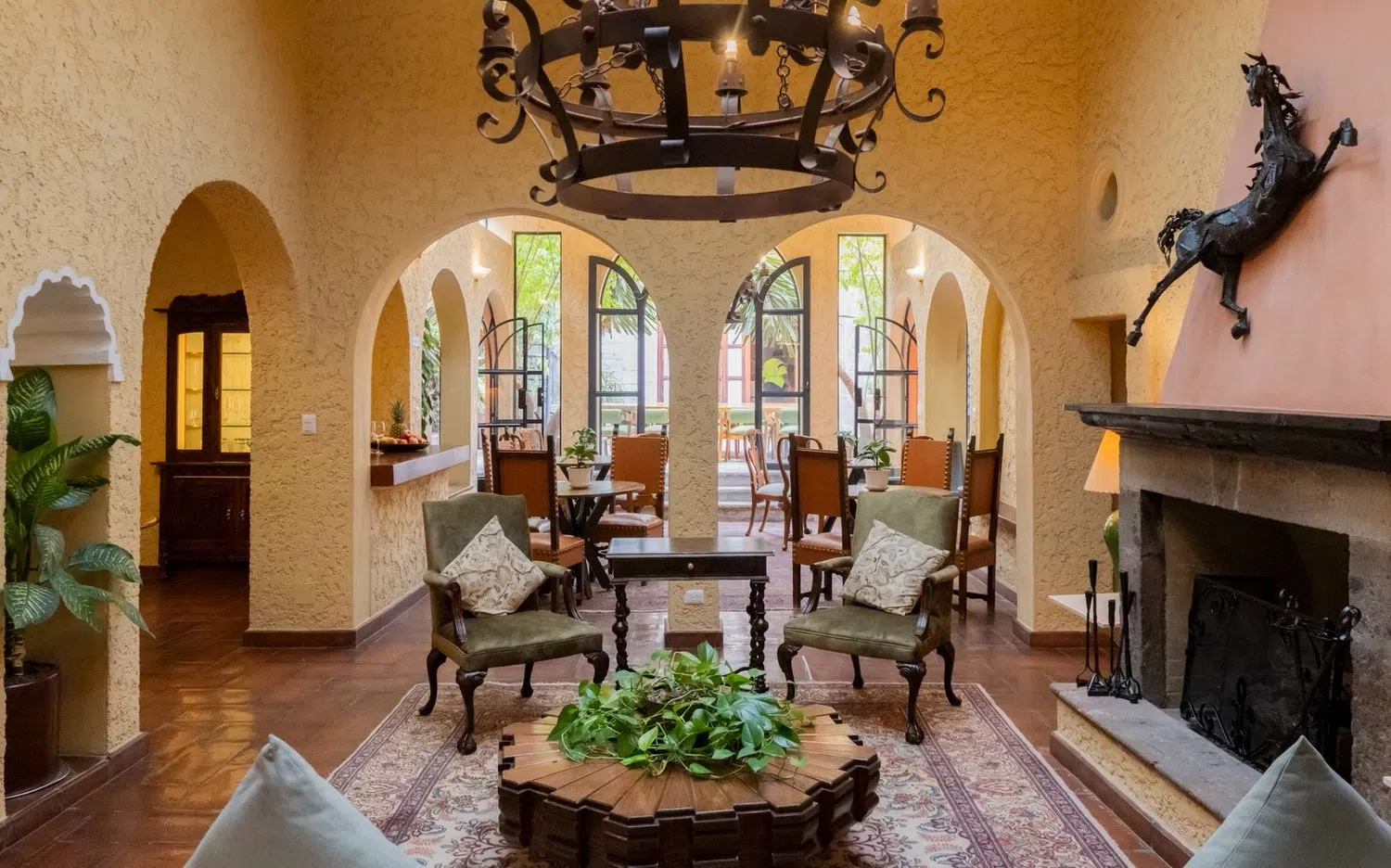 Sala con arcos, candil de hierro y chimenea, Hotel Xacalli San Miguel de Allende