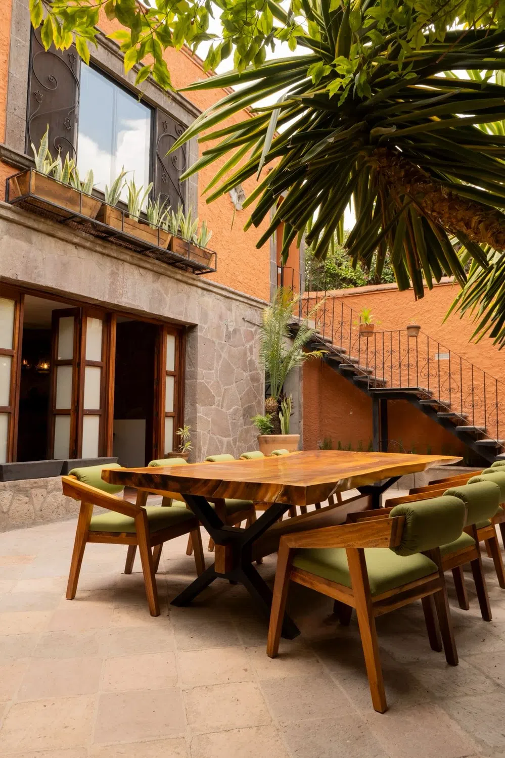 Patio ajardinado con mesa de madera, Hotel Xacalli